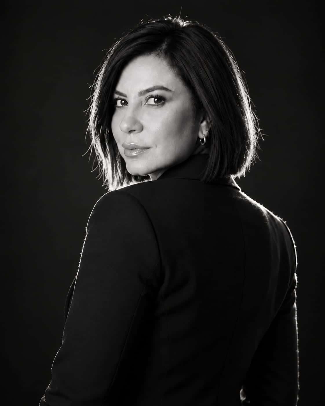 Simone Tatiana da Silva, advogada, em retrato em preto e branco, de costas, olhando por cima do ombro